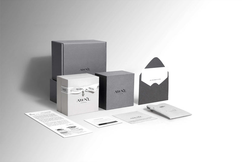 AWNL branded packaging set including boxes, an envelope, and brochures on a gray background