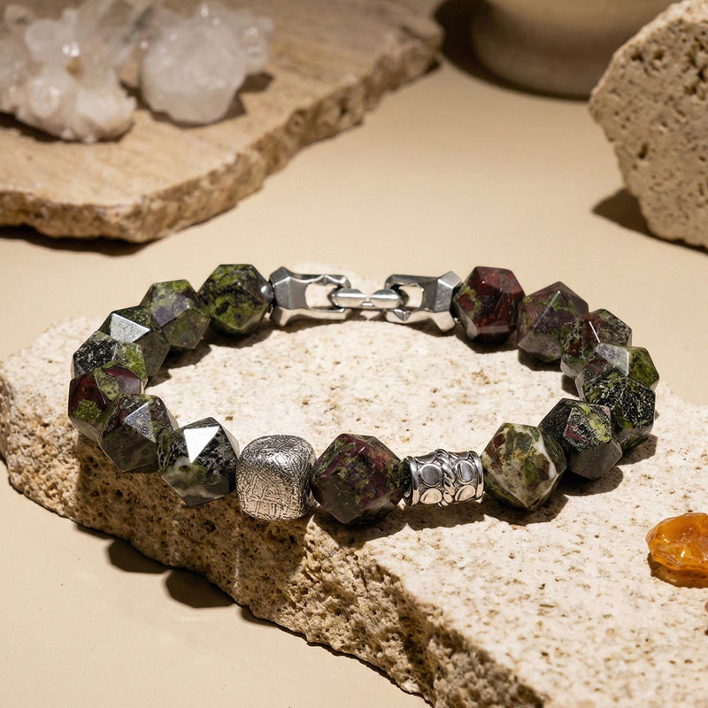 Bracelet with green and silver beads on a stone surface
